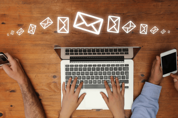 Close-up of sales reps typing on laptop and phones with email sequence graphic overlaid