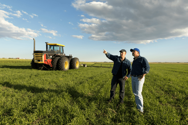 Two men talking in a field, representing sales farmers's desire to build and nurture relationships