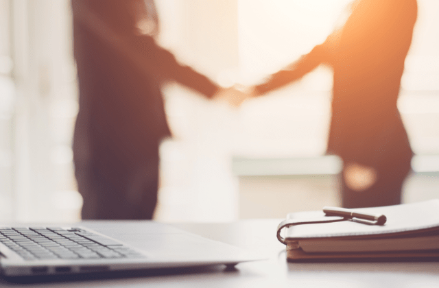 Blurry image of two people shaking hands